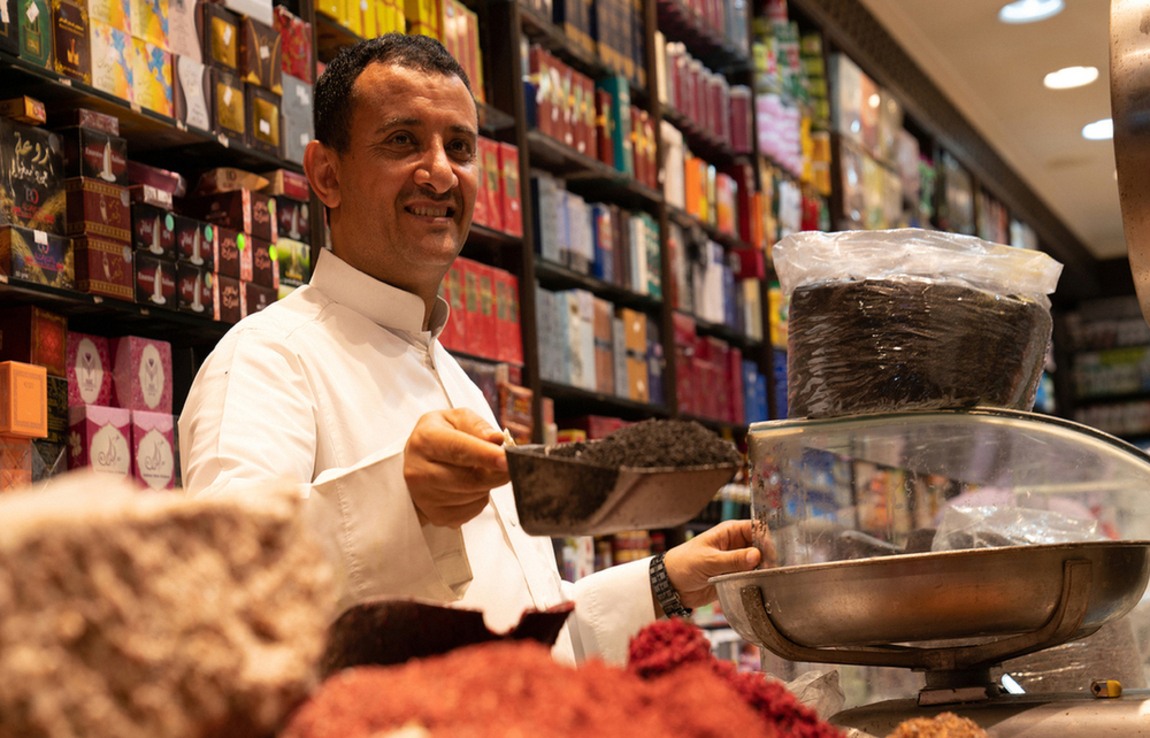A spice merchant and colourful goods in an Al-Balad market